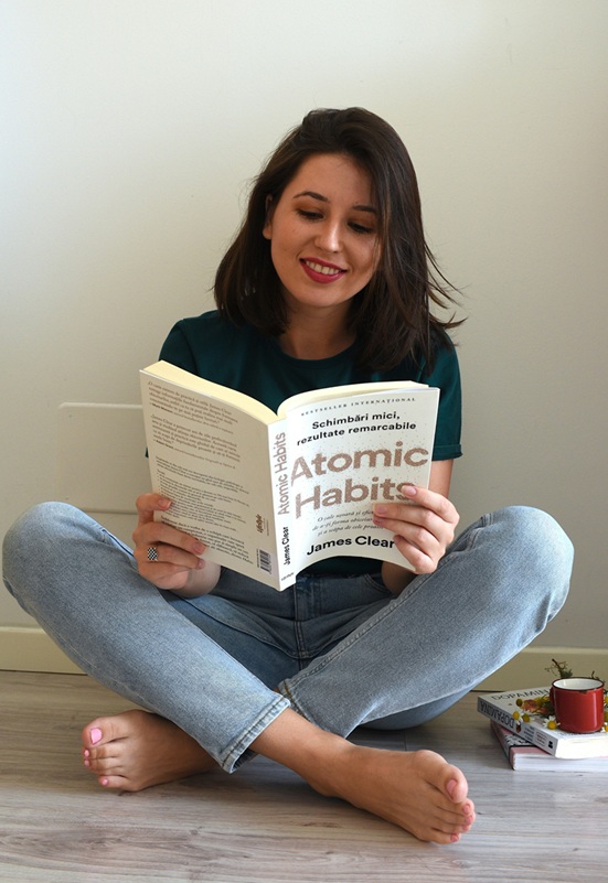 Woman reading Atomic Habits by James Clear